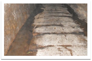 Tunnel floor showing evidence of railway sleeper postions and water course.